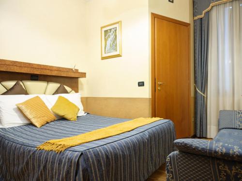 a hotel room with a bed and a chair at Atlantide Hotel in Venice