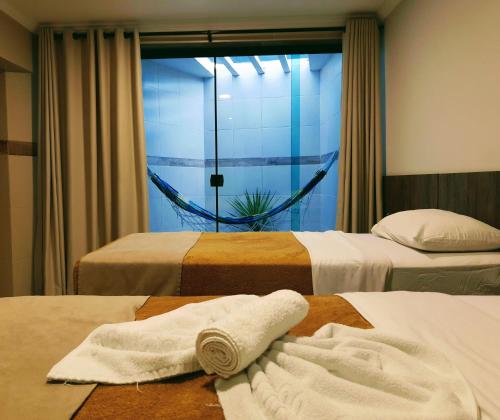 a hotel room with two beds and a window at Village Plaza Hotel in Barbacena
