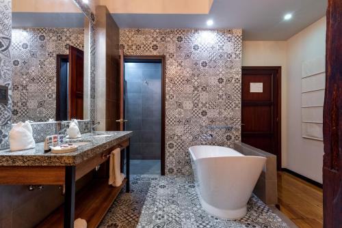 baño con bañera grande y lavamanos en Hotel La Cofradía Pub-House en Cuenca