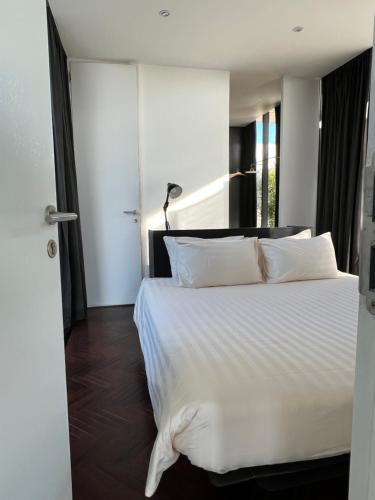 um quarto com uma cama branca e uma janela em DEEPSPACE cabin on Quiet Beach em Ko Lanta
