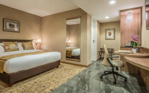 a hotel room with a bed and a desk at Marcian Garden Hotel in Zamboanga