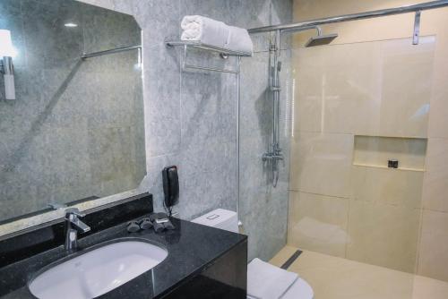 a bathroom with a sink and a shower at Marcian Garden Hotel in Zamboanga