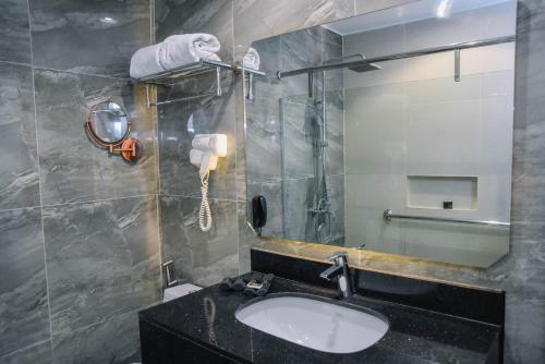 a bathroom with a sink and a mirror at Marcian Garden Hotel in Zamboanga