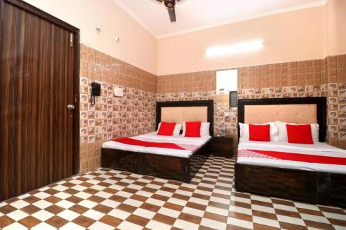 a bedroom with two beds and a checkered floor at Hotel KR AMRITSAR in Amritsar
