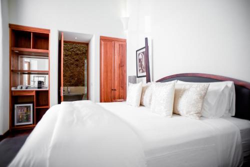 a bedroom with a white bed with white pillows at Hotel Casa Blanca 7 in San Miguel de Allende
