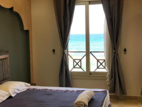 New Panorama Sea View Villa Family في العين السخنة: غرفة نوم مع نافذة مطلة على المحيط