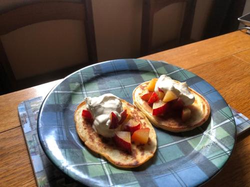 two pancakes with fruit and whipped cream on a glass plate at Foresters Lodge bed and breakfast, near loch ness in Inverfarigaig