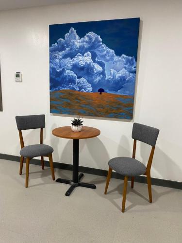 two chairs and a table with a painting on the wall at Go Hotels Plus Tuguegarao in Tuguegarao City