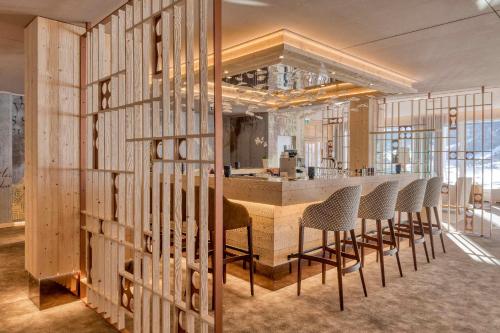 a room with a bar with chairs and a counter at Le Bristol Leukerbad in Leukerbad