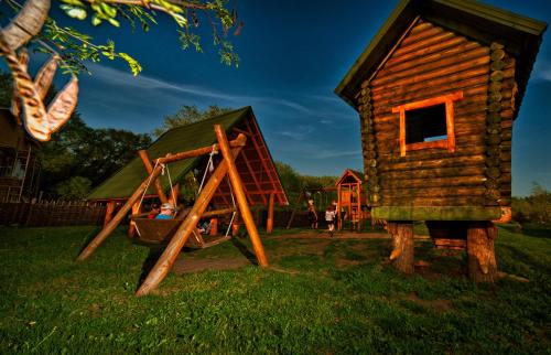 a log house and a playground in a yard at Gluhoman in Poltava