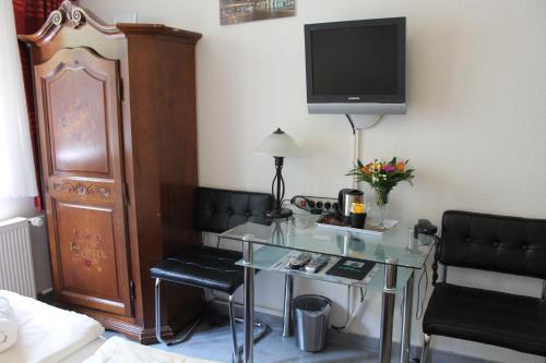 a hotel room with a desk and a tv in a room at Hotel Müller Köln in Cologne