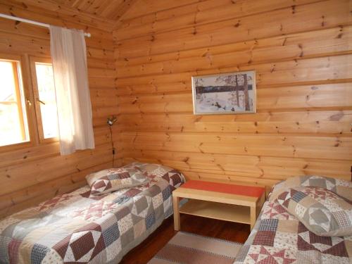 Blockhütte mit 2 Betten und einem Tisch in der Unterkunft Tornvillan in Hammarland