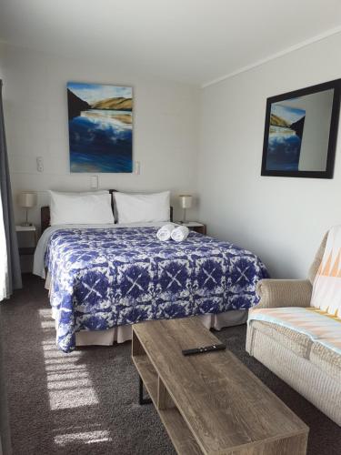 a hotel room with a bed and a couch at Paeroa Rail Trail Motel in Paeroa