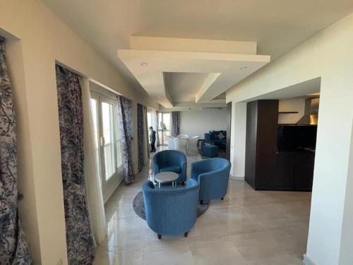 a hospital hallway with blue chairs and a table at Amazing sea view Penthouse Apartment in Pyramids Porto El-Sokhna in Ain Sokhna