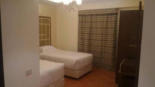 a bedroom with a bed and a couch and a window at Amazing sea view Penthouse Apartment in Pyramids Porto El-Sokhna in Ain Sokhna