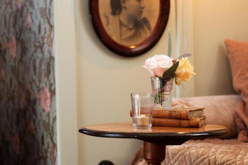 a table with a glass of water and flowers on it at Strandvillan Hotell och Bed & Breakfast in Lysekil