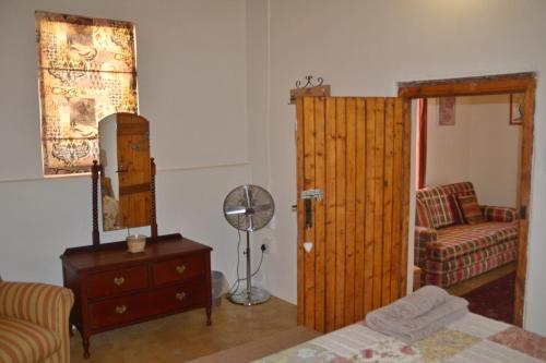 a bedroom with a bed and a chair and a door at The Lemon Tree in Prince Albert