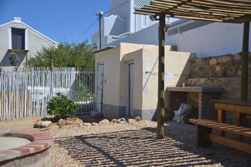 a backyard with a stone fireplace and a wooden bench at The Lemon Tree in Prince Albert