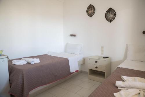 a hotel room with two beds and a night stand at Psiloritis Elena in Kalamaki Heraklion