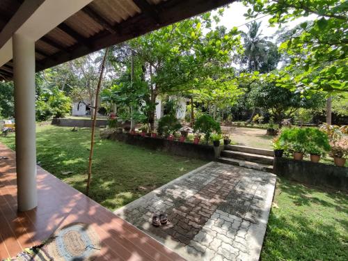 a view of a garden from the porch of a house at Deer Garden Guest in Polonnaruwa