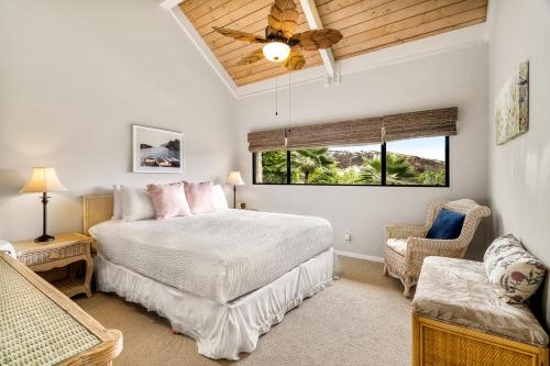 ein Schlafzimmer mit einem Bett, einem Stuhl und einem Fenster in der Unterkunft Keauhou Punahele B301 in Kailua-Kona