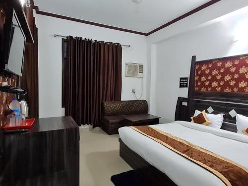 a hotel room with a bed and a chair at Hotel Broadway Katra by Geetanjali Group of Hotels in Katra