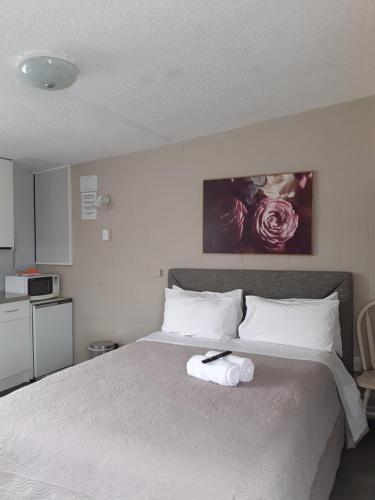 a bedroom with a bed with a towel on it at Paeroa Rail Trail Motel in Paeroa