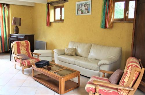 Orangerie LAGAILLARDE في Thil: غرفة معيشة مع أريكة وكراسي وطاولة