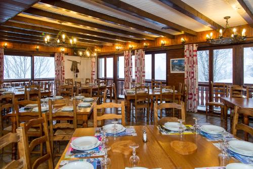 シャテルにあるGîte Châtelの木製のテーブルと椅子、窓のあるレストラン
