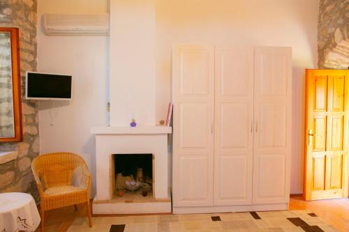 a living room with a fireplace and a white door at annemin harabesi otel in Cesme