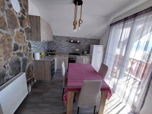 uma cozinha com uma mesa e uma cozinha com uma parede de pedra em Tetka Viki em Mavrovo