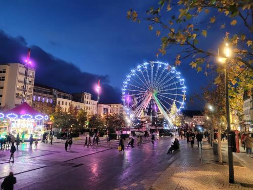 ein großes Riesenrad in einer Stadt nachts in der Unterkunft The Originals Access, Hôtel Clermont-Ferrand Nord in Châteaugay