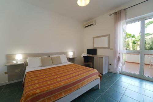 - une chambre avec un lit et une grande fenêtre dans l'établissement Europa rooms and restaurant, à Capo Vaticano