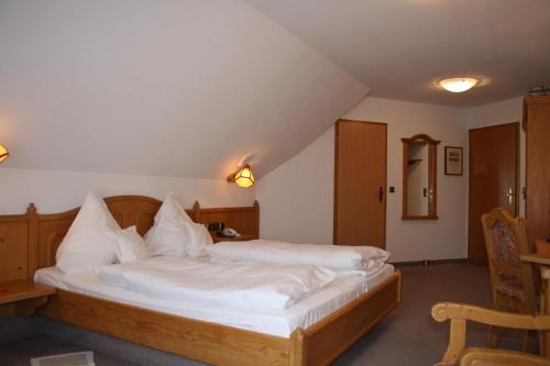 Schlafzimmer mit einem Bett mit weißer Bettwäsche und Kissen in der Unterkunft Die Krone in Staufen im Breisgau