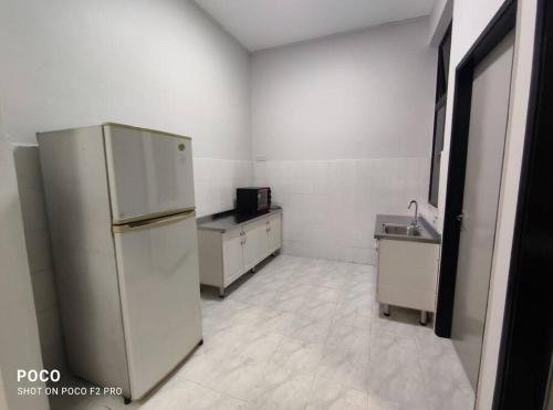 a kitchen with a refrigerator and a sink at 55 homestay 4-bedrooms guesthouse in Bukit Bakri Muar Johor in Bakri