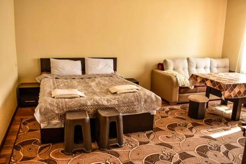 ein Schlafzimmer mit einem großen Bett und einem Sofa in der Unterkunft НАПРОТИВ СПОРТИВНО-КОНЦЕРТНОГО КОМПЛЕКСА in Yerevan