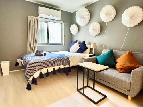 a bedroom with a bed and a couch at Ritz Place Nishikujo in Osaka