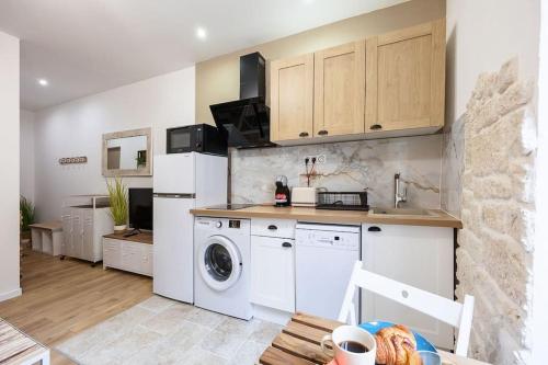 eine Küche mit Waschmaschine und Waschmaschine in der Unterkunft Exotic Stones Hyper Centre Fontaine Moussue in Salon-de-Provence