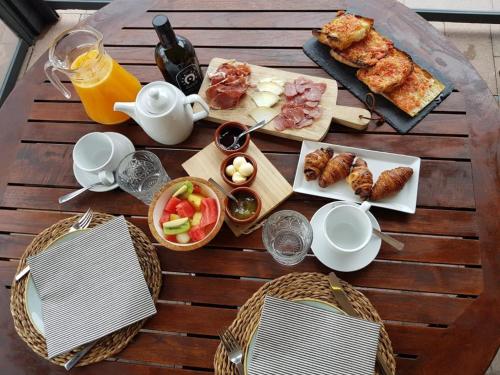 Una mesa con comida y bebidas sobre una mesa de madera. en Hotel Sa Tuna, en Begur