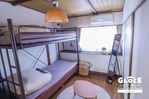 a small room with bunk beds and a chair at GLOCE 葉山 ゲストハウス l 一色海岸のそばでペットと一緒にシーサイドライフ in Hayama