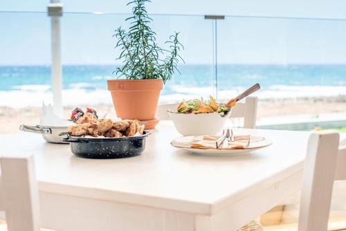 a table with food on it with the beach in the background at Piere - Anne Beach Hotel in Ayia Napa