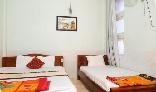 a hotel room with two beds and a window at Binh An Hostel in Hue