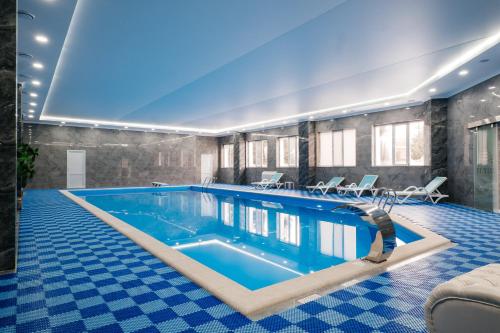 a large swimming pool in a building with blue tiles at El-Tau in Ekibastuz