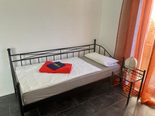 - un lit avec un oreiller rouge dans l'établissement Pension Kaufungen, à Kaufungen