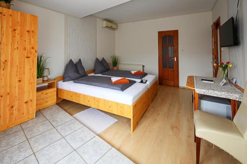 a bedroom with a large bed and a desk at Nádasdi Ház in Szekszárd