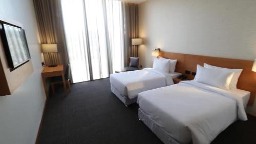 a hotel room with two beds and a window at The Vern at BLVD in Nashik