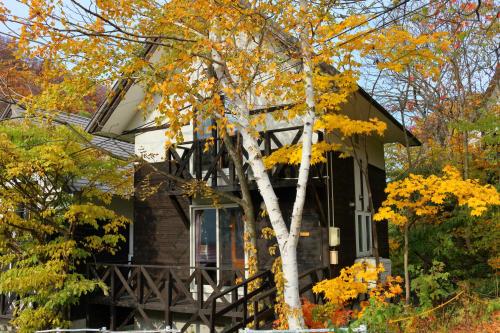 una casa en otoño con un árbol en Winkel Village, en Otaru