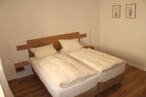 a bed with white sheets and pillows in a room at Gasthaus Löwen in Sinsheim