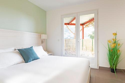 een witte slaapkamer met een bed en een raam bij SELECT'SO HOME - Résidence La Fossette - Prestations de qualité & Services Hôteliers - FOS-02 in Le Lavandou