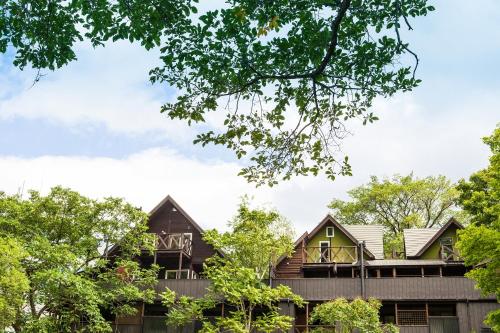 una casa en el bosque con árboles en Winkel Village en Otaru